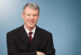 white man smiling into camera in a business suit